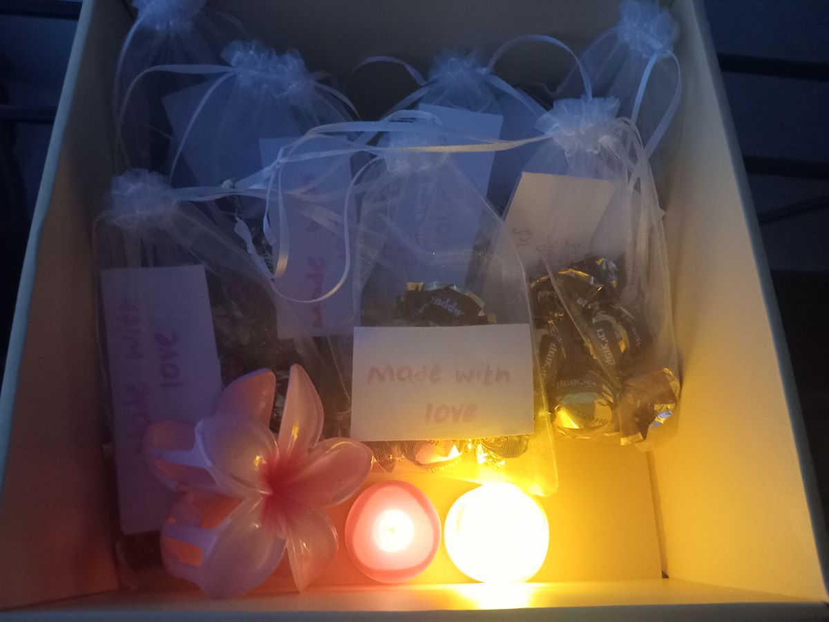 קופסה עם מתנות עטופות בשקיות כחולות ונרות דולקים